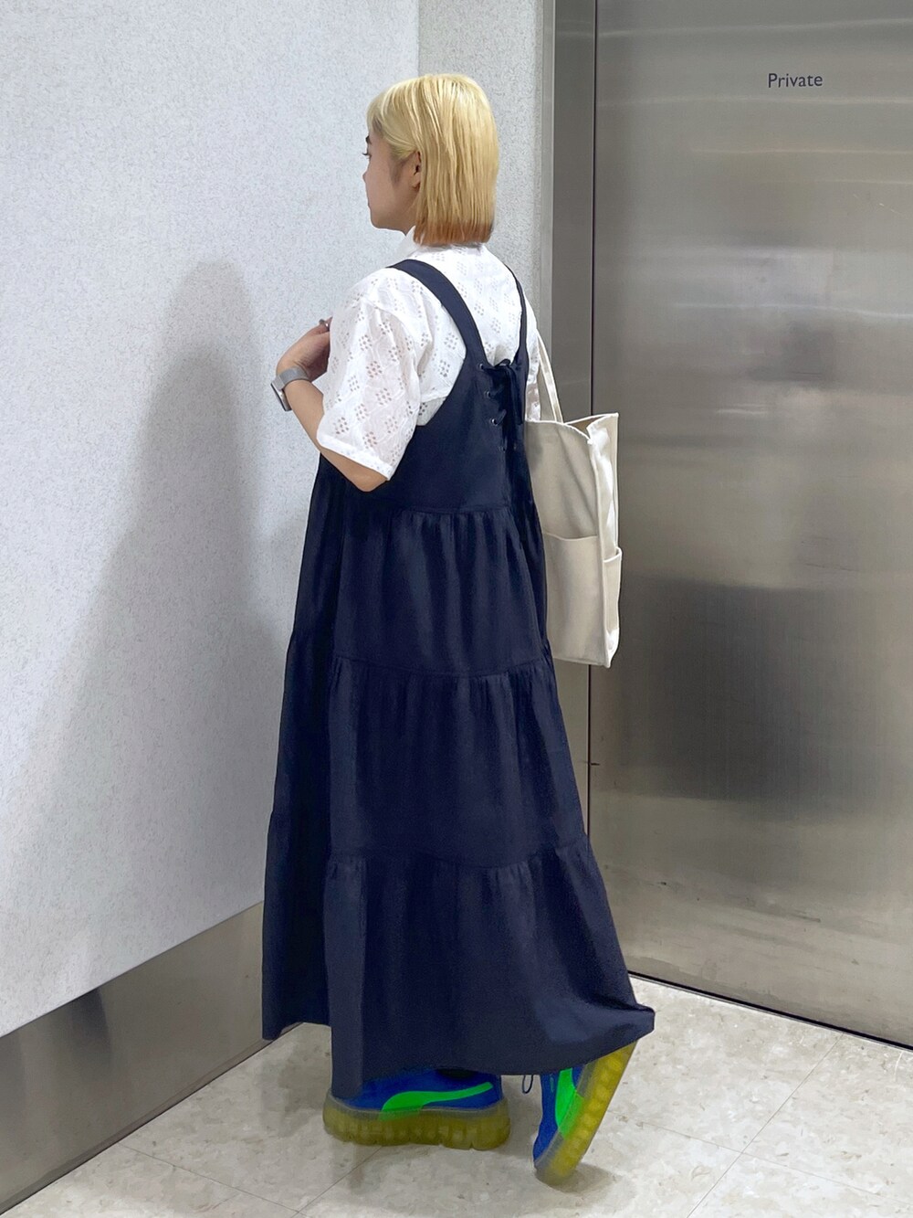 ホワイト系のトートバッグ、ブルー系のワンピース、ホワイト系のシャツ/ブラウスを着用したレディースの夏コーディネートの2枚目の写真