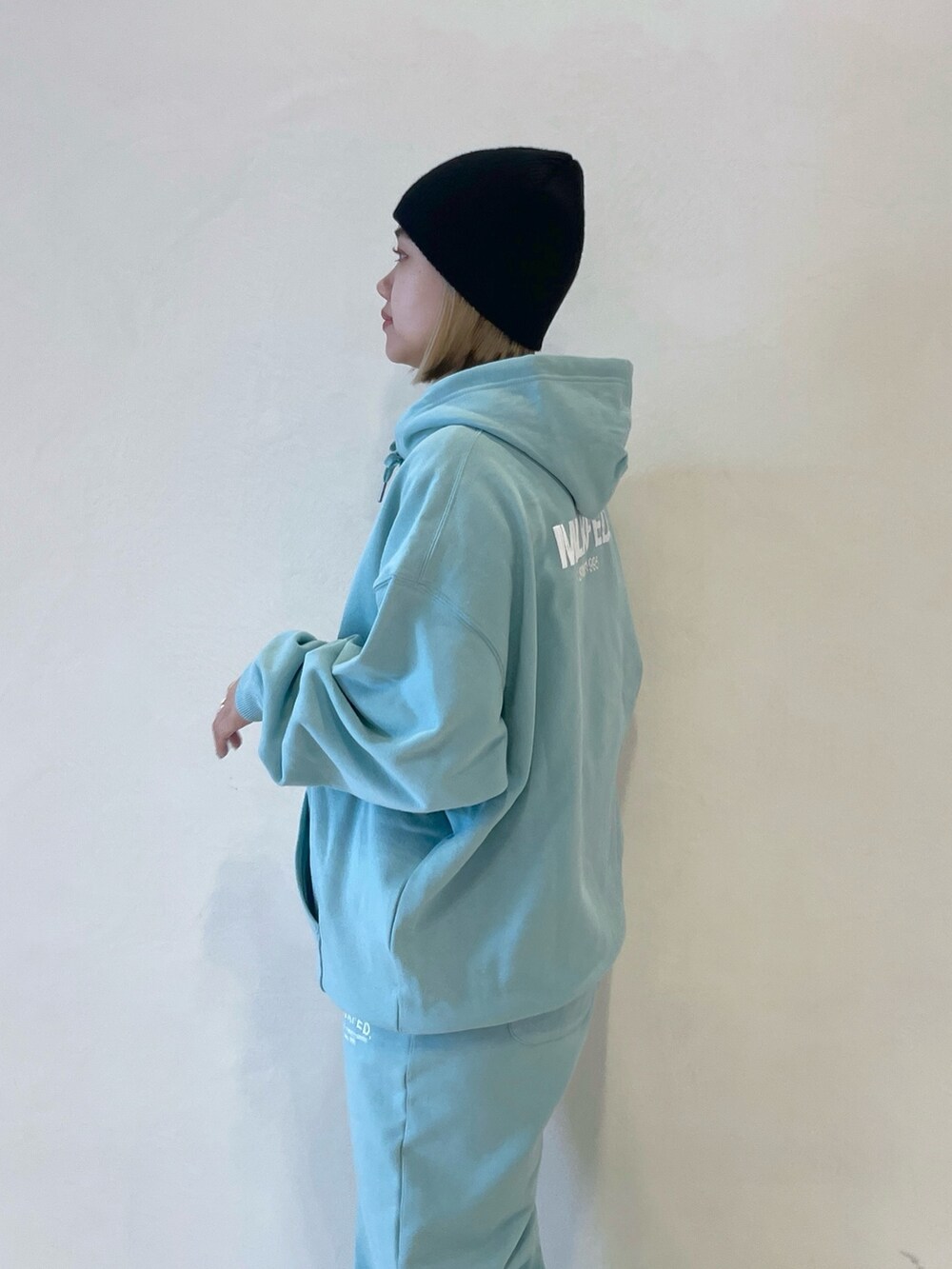 グリーン系のパーカー、グリーン系のスウェットパンツ、ブラック系のバックパック/リュックを着用したレディースの冬コーディネートの7枚目の写真