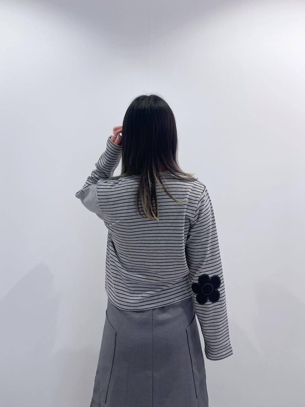 グレー系のスカート、ブラック系のショルダーバッグ、グレー系のカーディガン/ボレロを着用したレディースの秋コーディネートの8枚目の写真