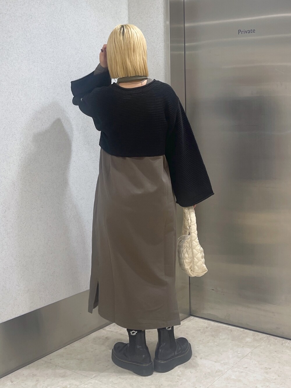 ブラック系のカーディガン/ボレロ、グリーン系のワンピース、ホワイト系のハンドバッグを着用したレディースの秋コーディネートの5枚目の写真