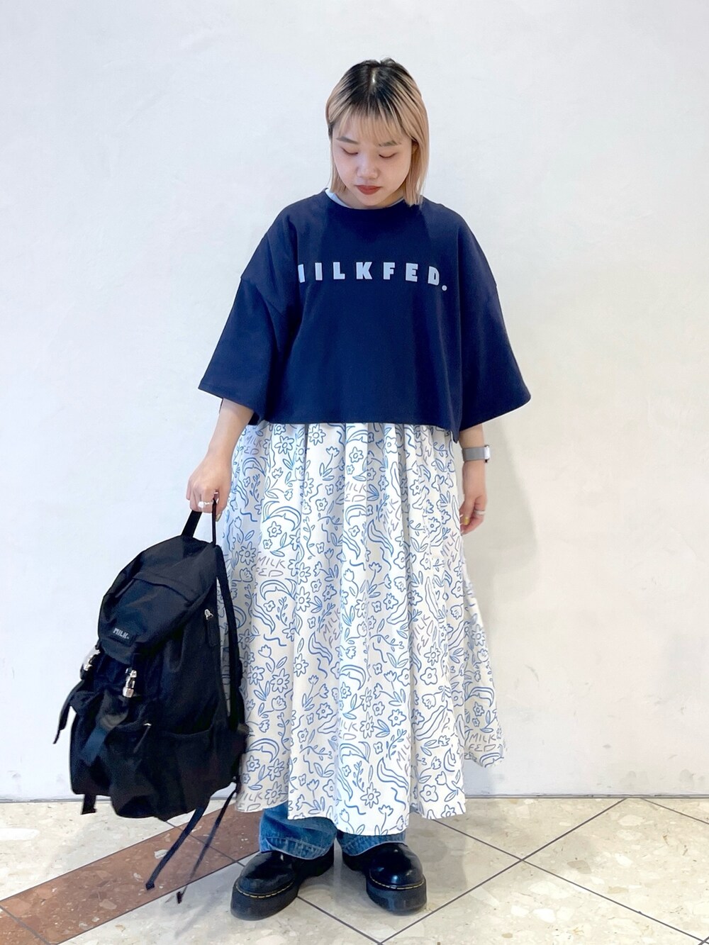 ホワイト系のワンピース、ブルー系のTシャツ/カットソー、ブラック系のブーツを着用したレディースの夏コーディネートの2枚目の写真