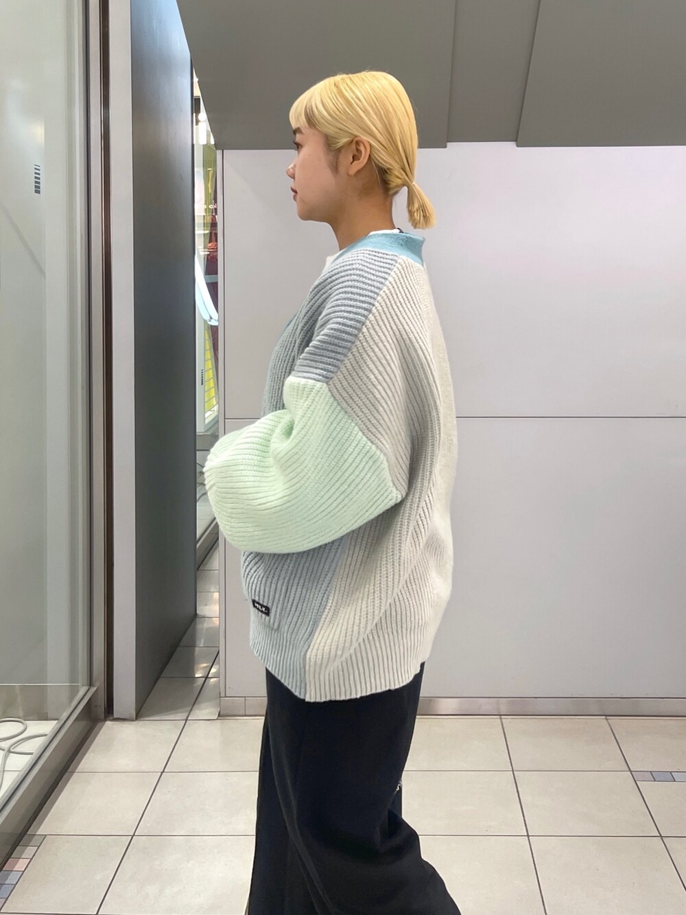 ブラック系のスウェットパンツ、ブルー系のトートバッグ、グリーン系のカーディガン/ボレロを着用したレディースの冬コーディネートの8枚目の写真