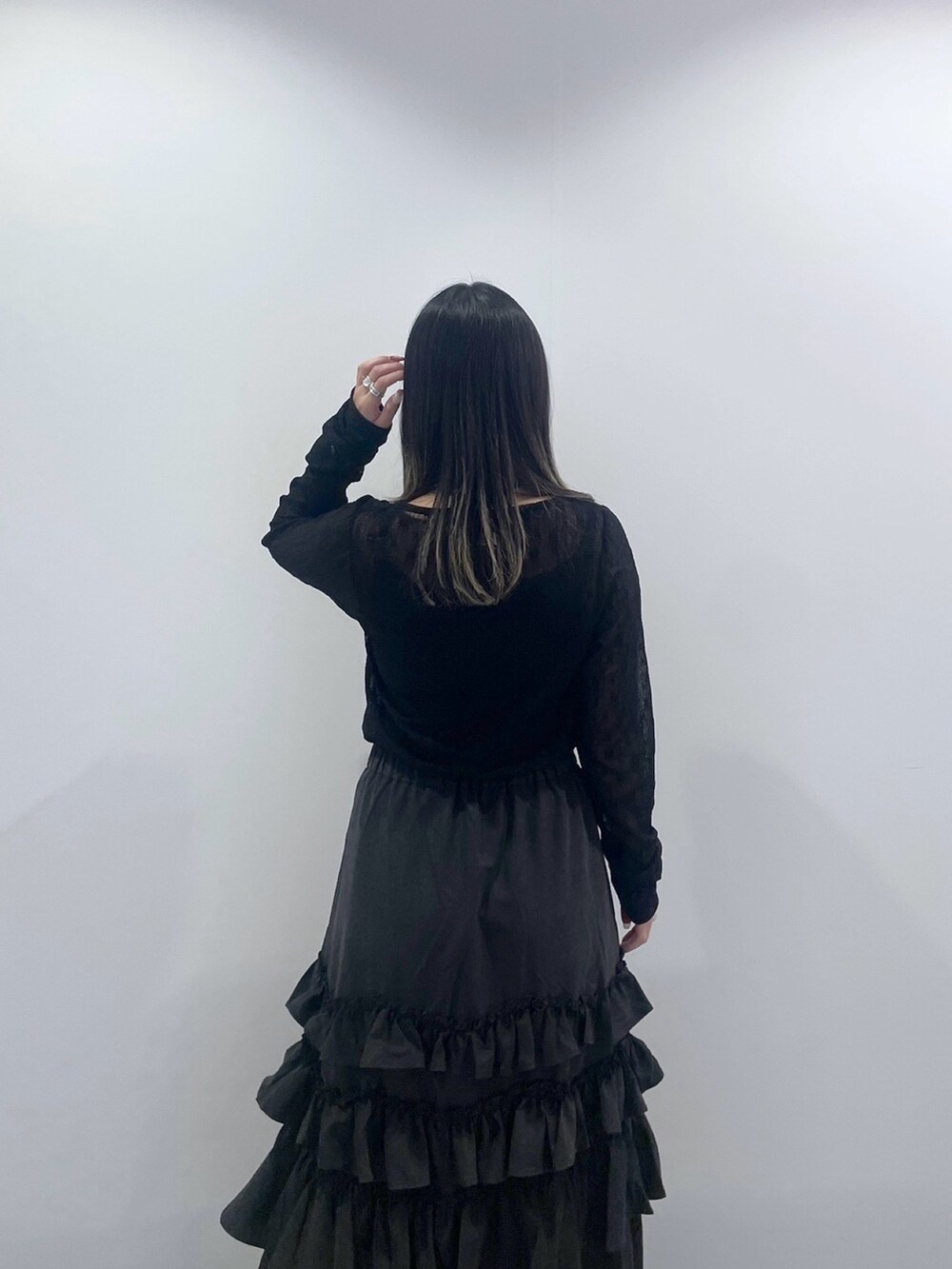 ブラック系のTシャツ/カットソー、ブラック系のスカート、ホワイト系のハンドバッグを着用したレディースの秋コーディネートの9枚目の写真