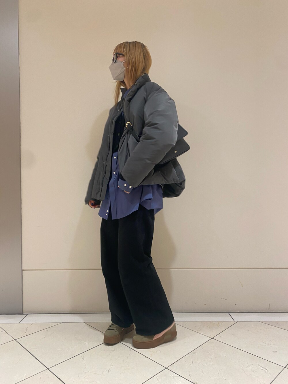 グレー系のダウンジャケット/コート、ブラック系のカーディガン/ボレロを着用したレディースの冬コーディネートの2枚目の写真