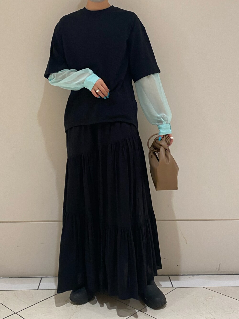 ブラック系のTシャツ/カットソー、イエロー系のハンドバッグ、ブラック系のスカートを着用したレディースの春コーディネートの3枚目の写真