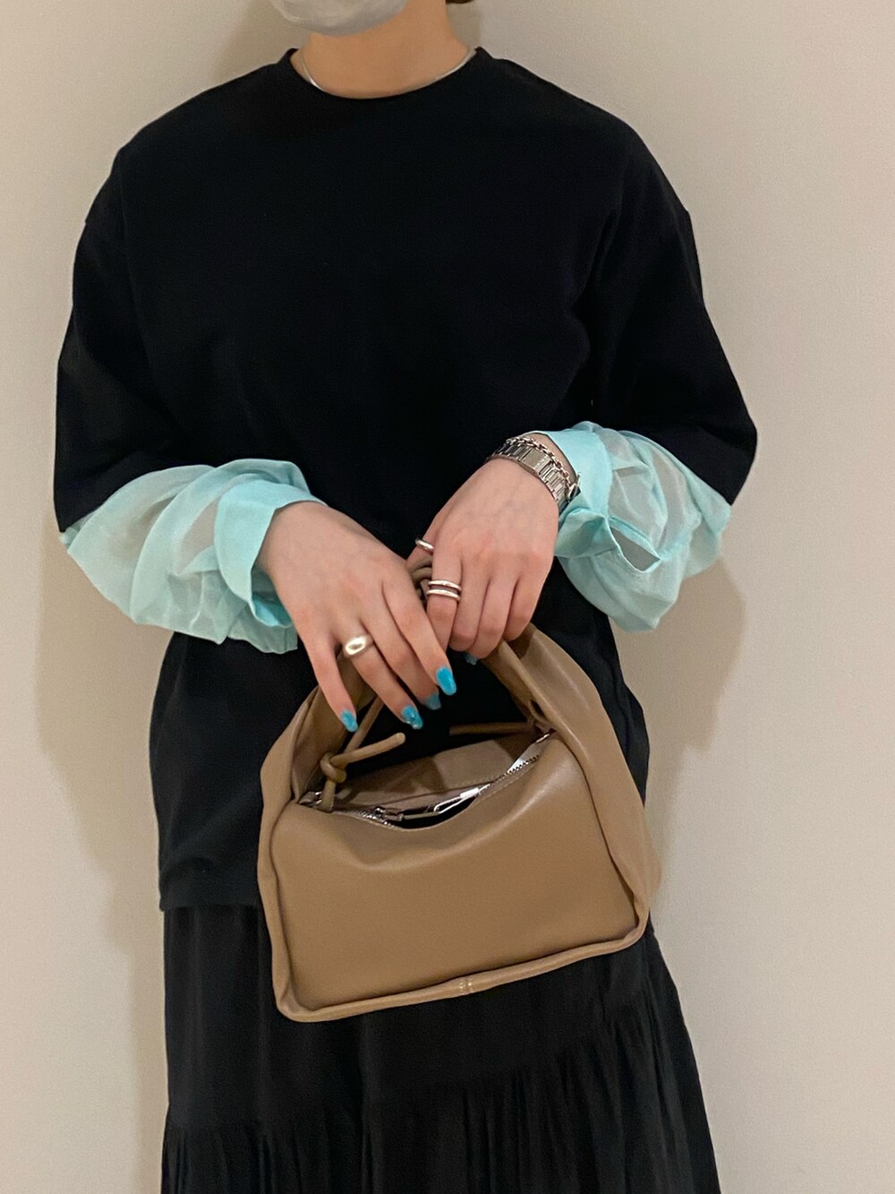 ブラック系のTシャツ/カットソー、イエロー系のハンドバッグ、ブラック系のスカートを着用したレディースの春コーディネートの4枚目の写真