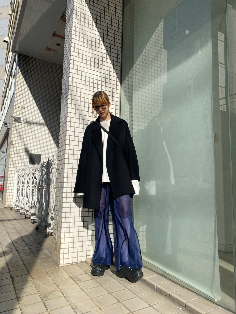 ブラック系のショルダーバッグ、ブラック系のチェスターコートを着用したレディースの冬コーディネートの2枚目の写真