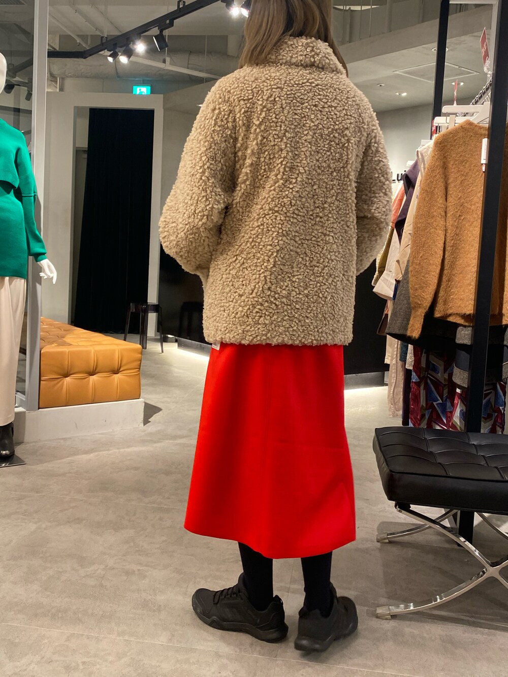 ブラック系のTシャツ/カットソー、ベージュ系のムートンコート、レッド系のスカートを着用したレディースの冬コーディネートの2枚目の写真