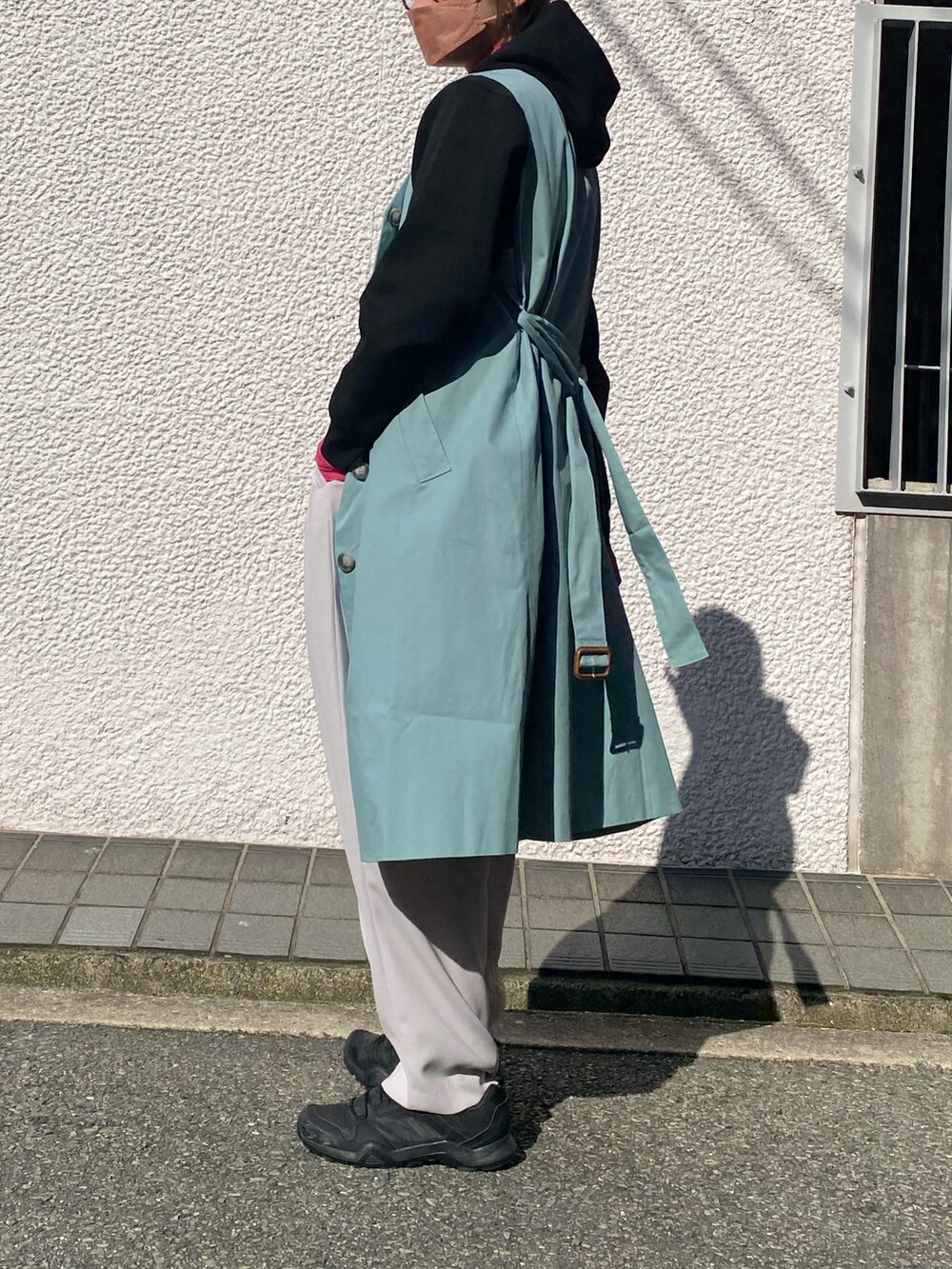 ブラック系のパーカー、グレー系のスラックス、ピンク系のTシャツ/カットソーを着用したレディースの冬コーディネートの4枚目の写真