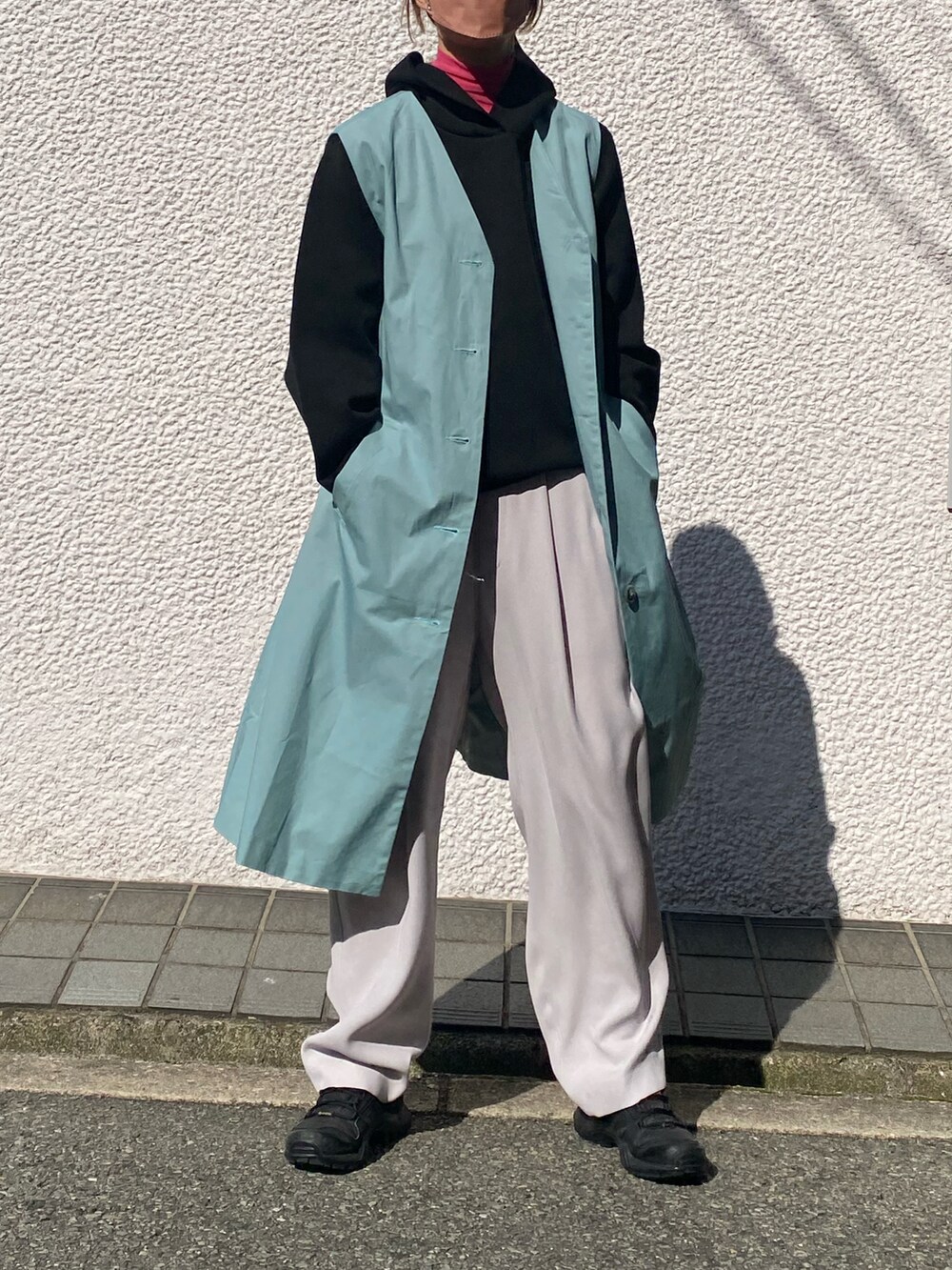 ブラック系のパーカー、グレー系のスラックス、ピンク系のTシャツ/カットソーを着用したレディースの冬コーディネートの2枚目の写真