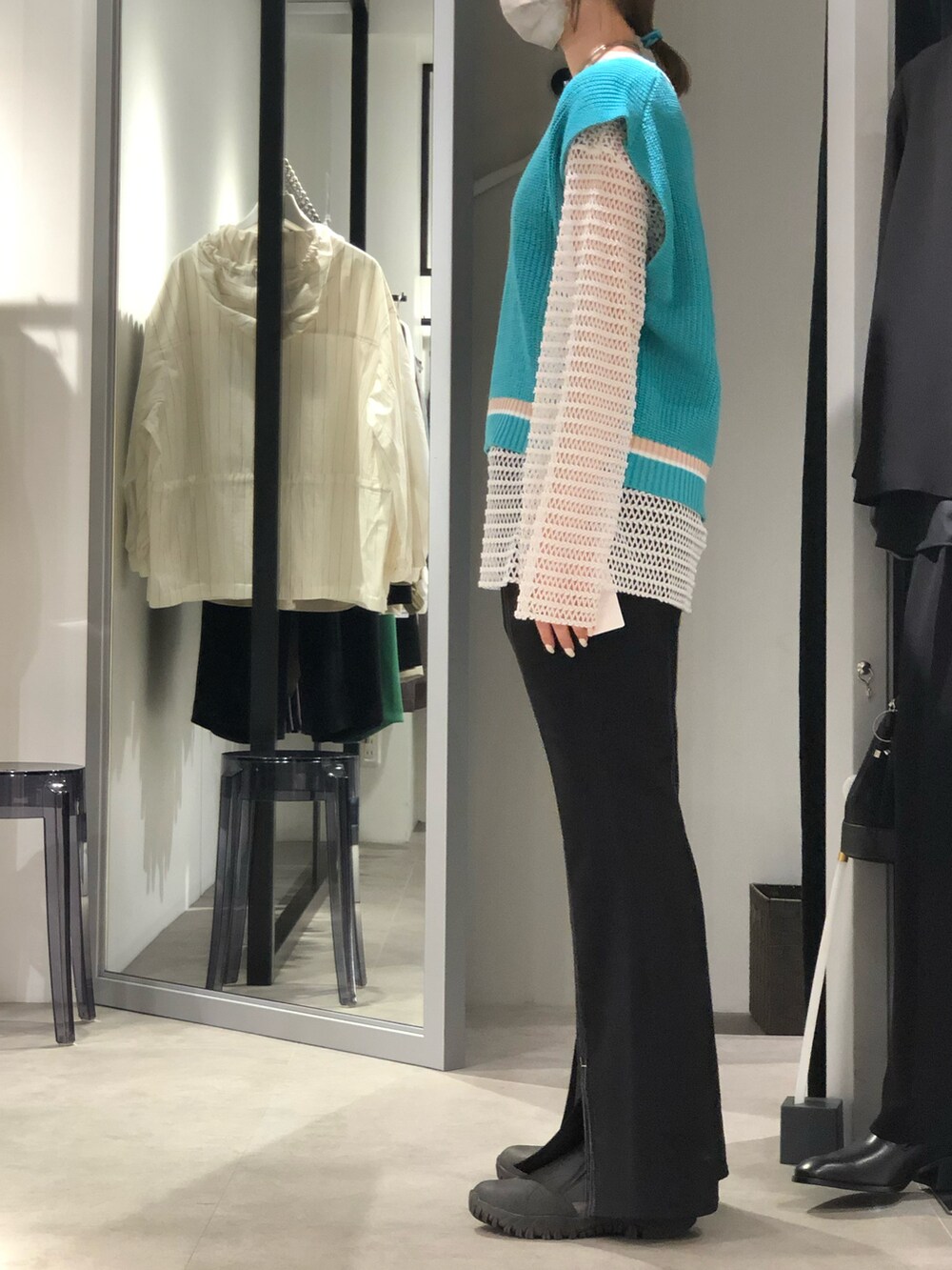 ブルー系のベスト、ブラック系のスラックス、ホワイト系のTシャツ/カットソーを着用したレディースの春コーディネートの2枚目の写真