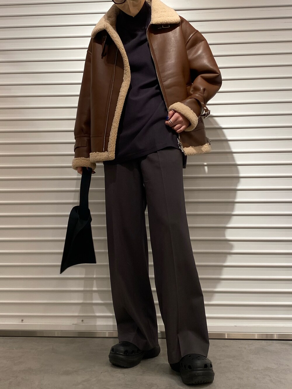 ブラウン系のミリタリージャケット、グレー系のスラックスを着用したレディースの冬コーディネートの2枚目の写真