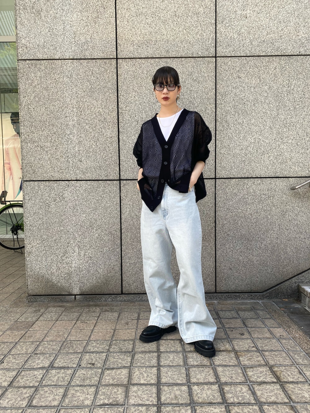 ブラック系のカーディガン/ボレロ、ブルー系のデニムパンツ、ブラック系のドレスシューズを着用したレディースの春コーディネートの2枚目の写真