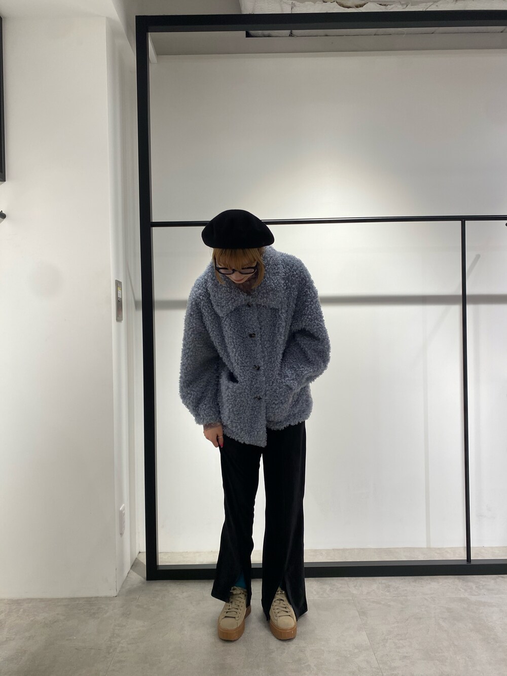 ブルー系のムートンコート、ブラック系のその他パンツを着用したレディースの冬コーディネートの2枚目の写真