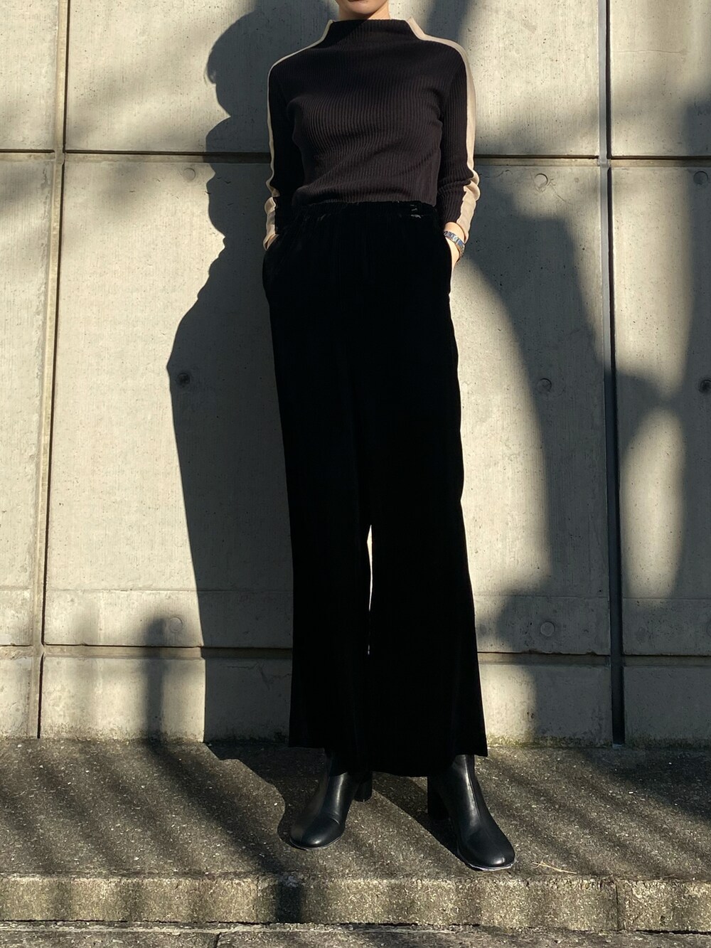 ブラック系のニット/セーター、ブラック系のその他パンツ、ブラック系のブーツを着用したレディースの冬コーディネートの3枚目の写真