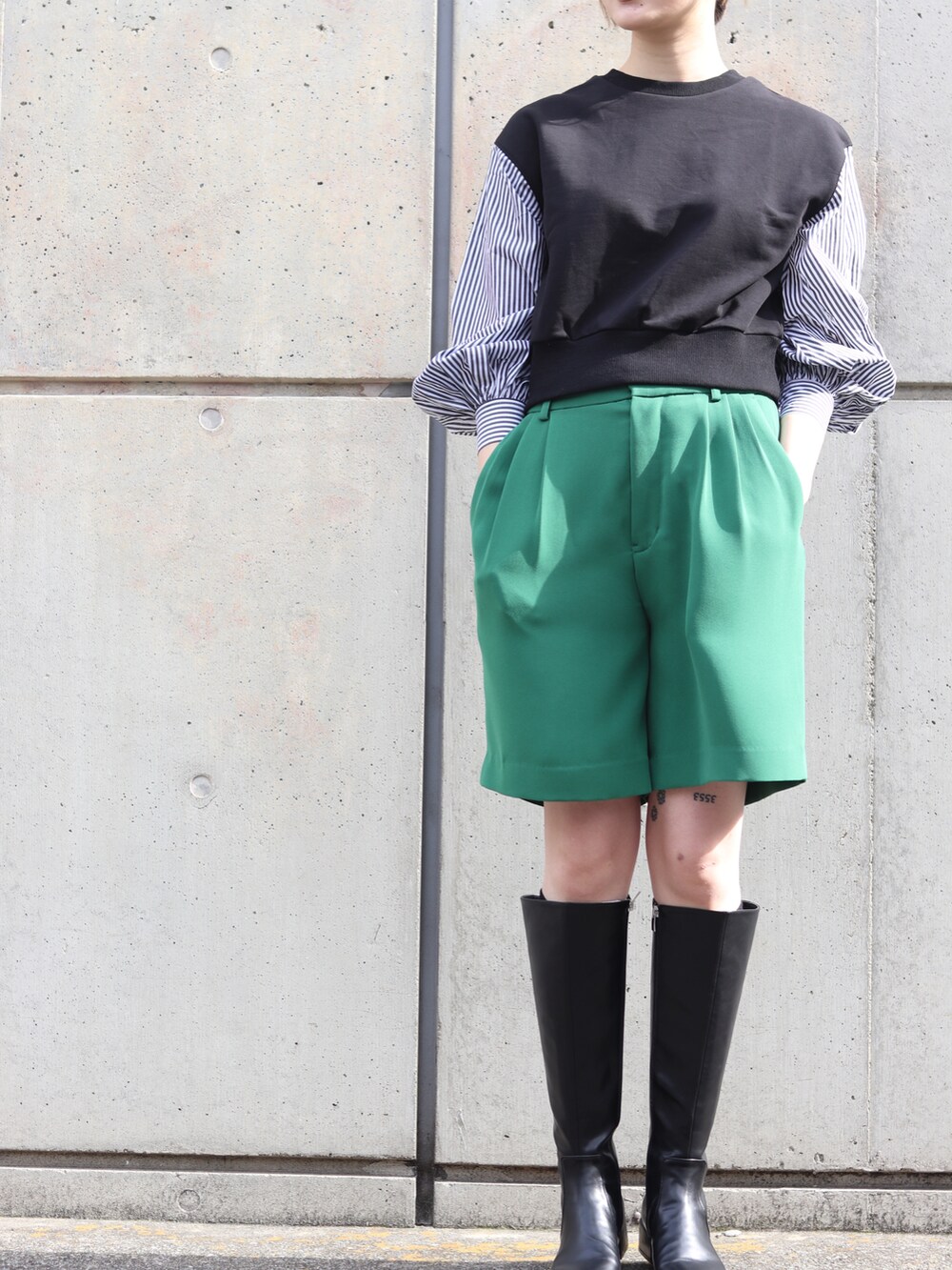 ブラック系のスウェット、グリーン系のスラックスを着用したレディースの冬コーディネートの2枚目の写真