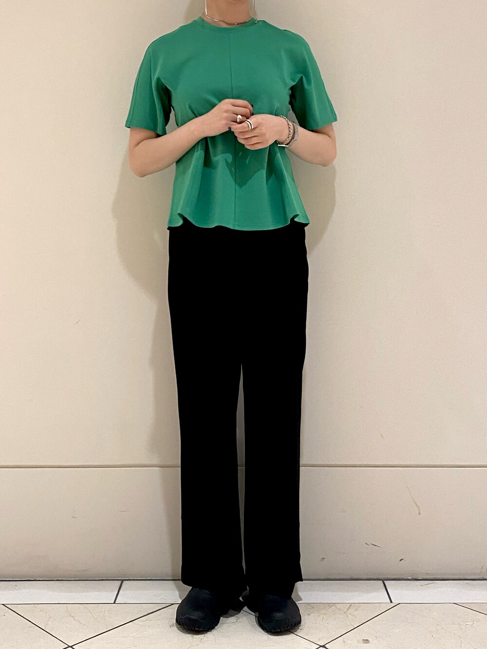 グリーン系のTシャツ/カットソー、ブラック系のスラックスを着用したレディースの夏コーディネートの2枚目の写真
