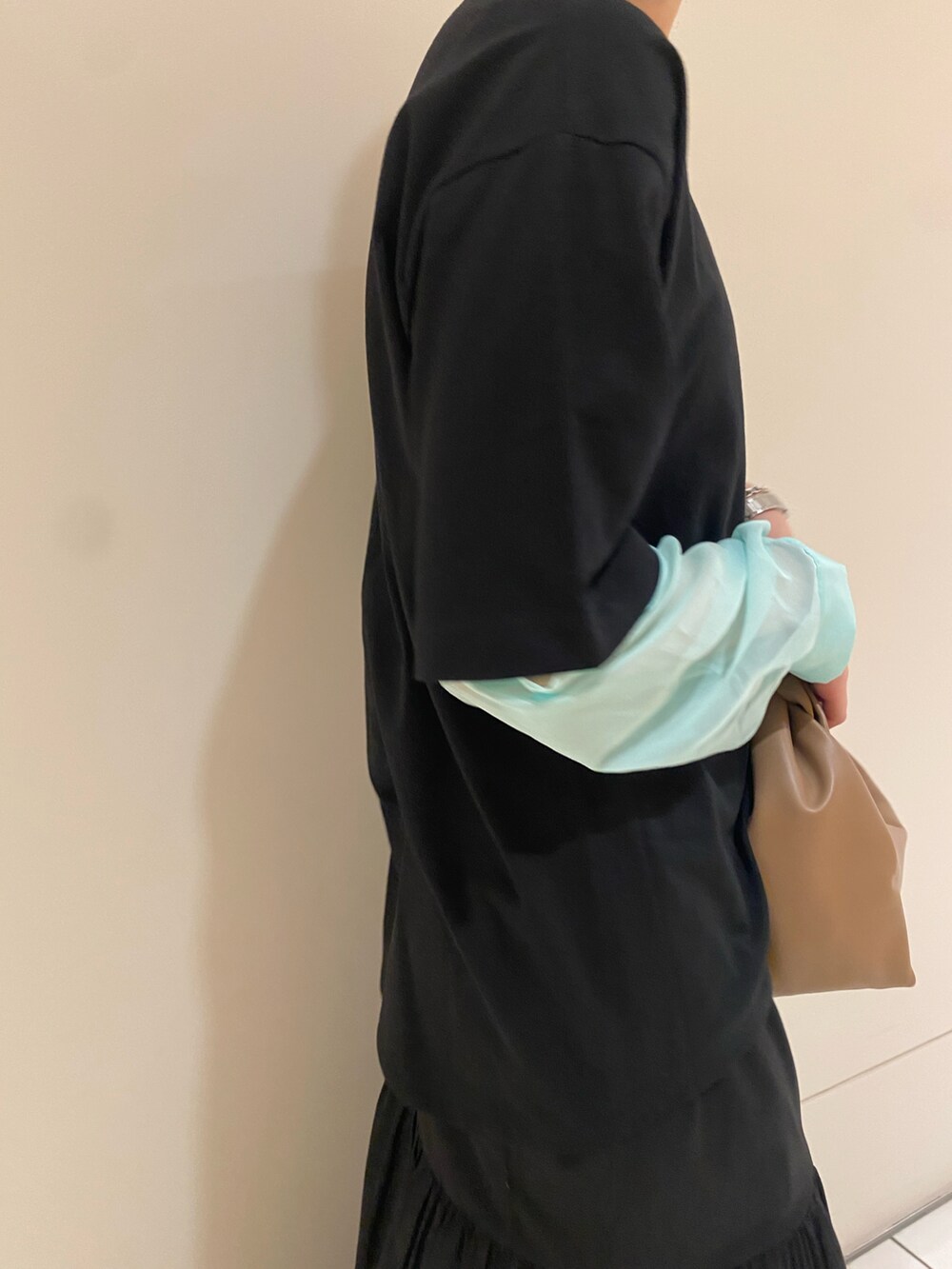 ブラック系のTシャツ/カットソー、イエロー系のハンドバッグ、ブラック系のスカートを着用したレディースの春コーディネートの5枚目の写真