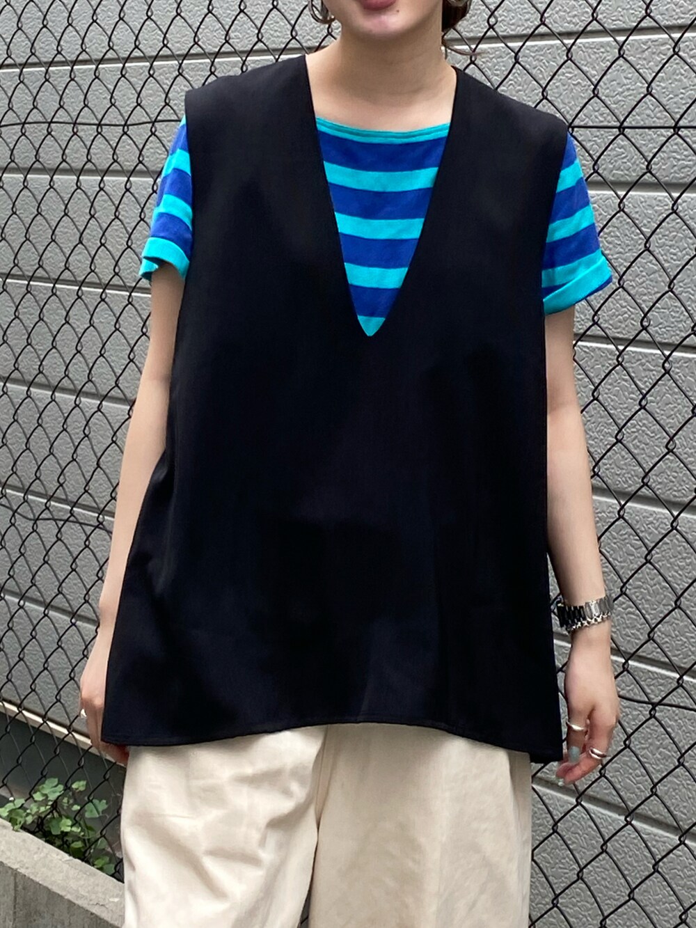 ブラック系のベストを着用したレディースの夏コーディネートの2枚目の写真