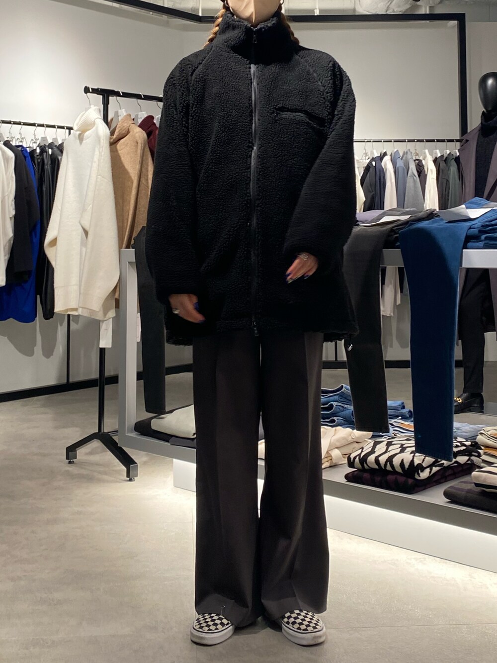 ブラック系のブルゾン、グレー系のスラックスを着用したレディースの冬コーディネートの2枚目の写真