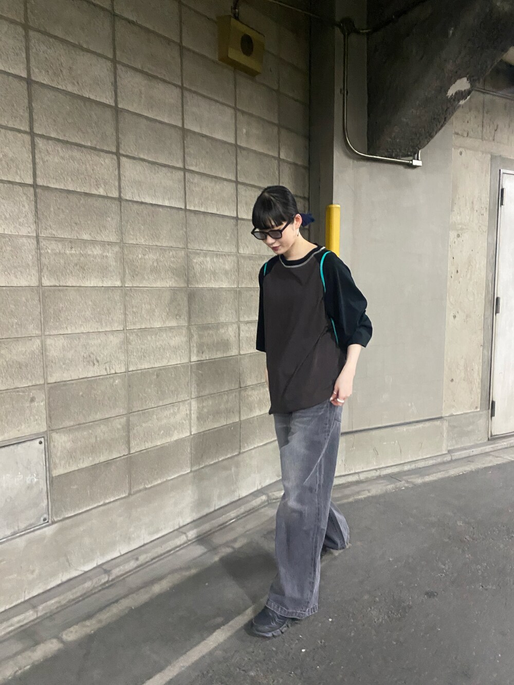 ブラック系のデニムパンツ、ブルー系のトートバッグを着用したレディースの春コーディネートの2枚目の写真