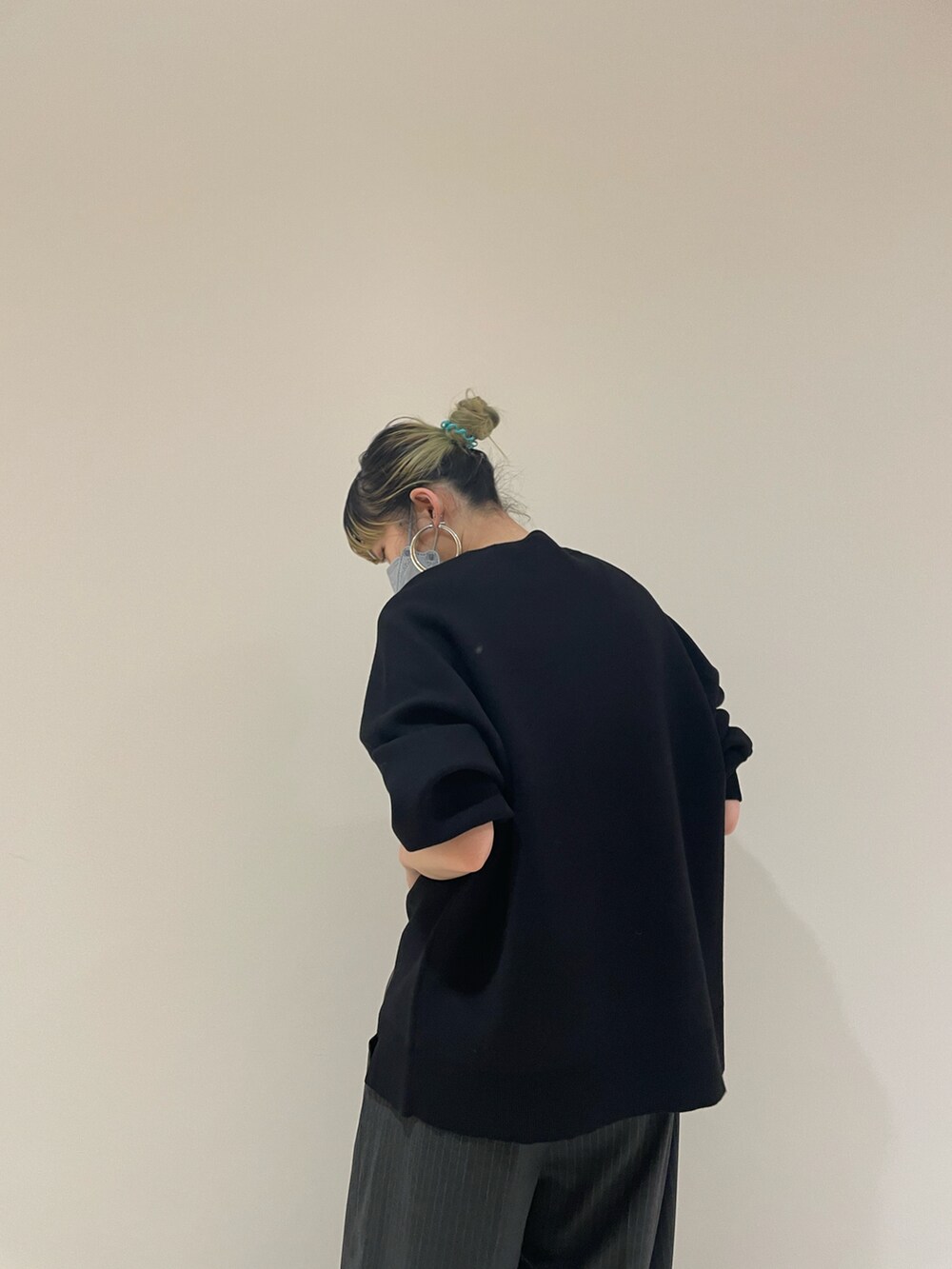 ブラック系のニット/セーター、グレー系のスラックス、ブラック系のハンドバッグを着用したレディースの秋コーディネートの2枚目の写真