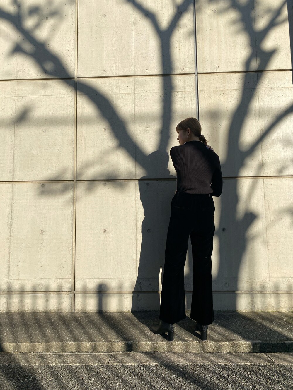 ブラック系のニット/セーター、ブラック系のその他パンツ、ブラック系のブーツを着用したレディースの冬コーディネートの2枚目の写真