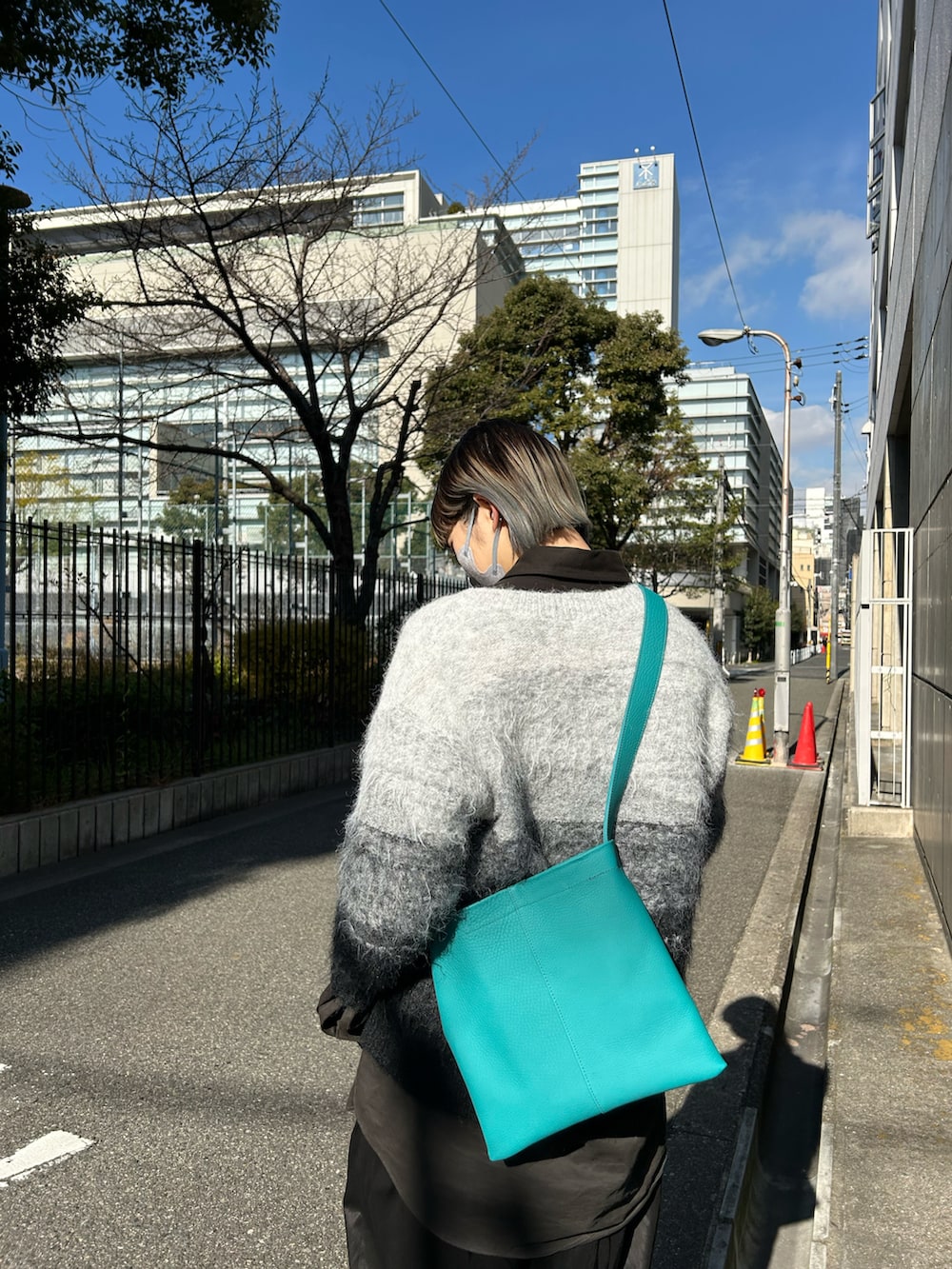 ブルー系のバッグ、グレー系のニット/セーターを着用したレディースの冬コーディネートの2枚目の写真