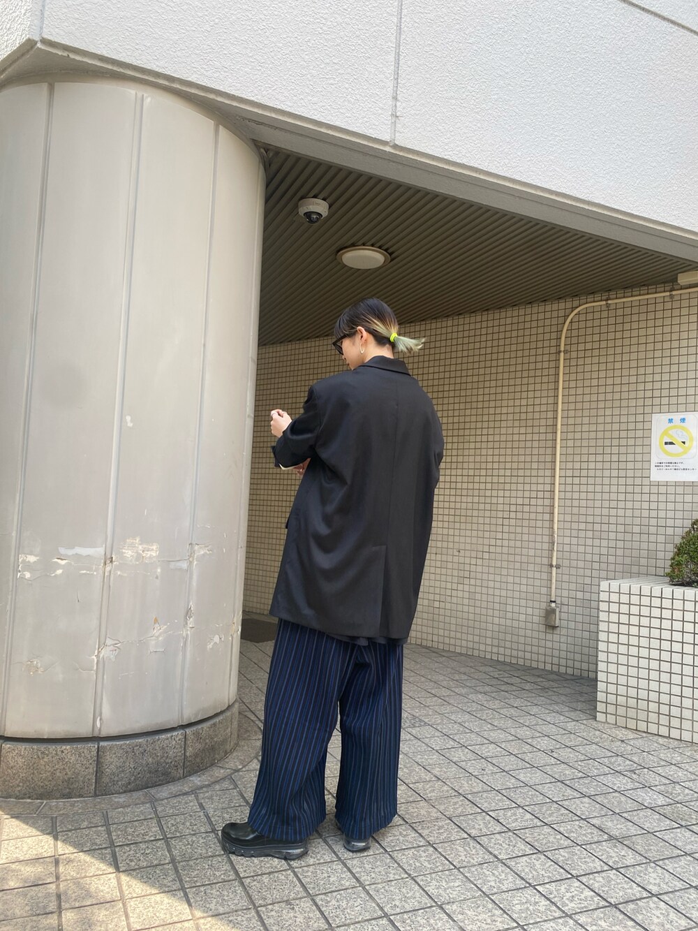 ブラック系のテーラードジャケットを着用したレディースの春コーディネートの2枚目の写真