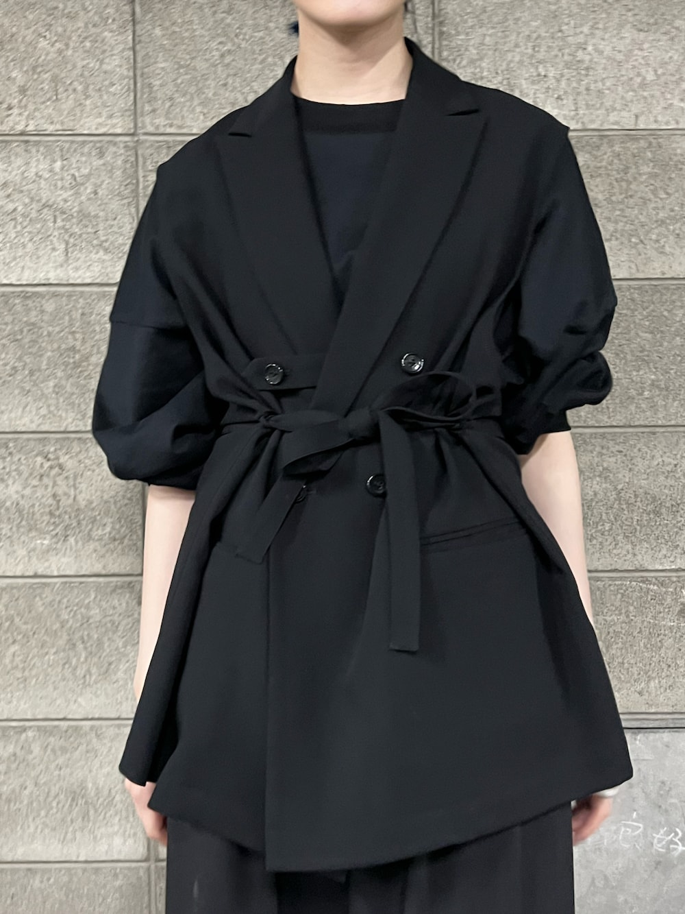 ブラック系のベスト、ブラック系のスラックスを着用したレディースの春コーディネートの4枚目の写真