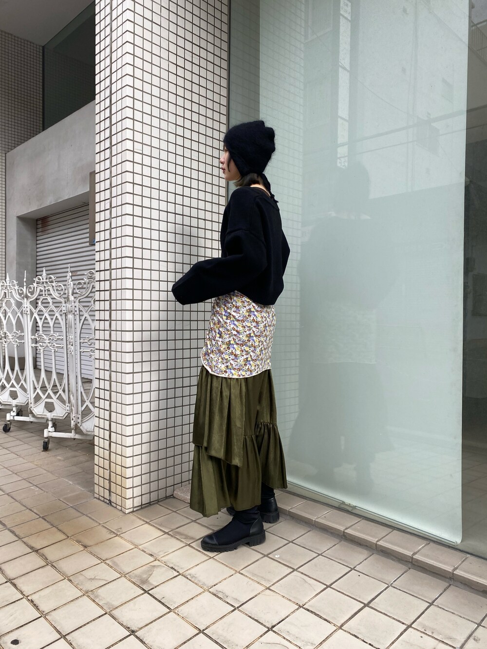 ブラック系のカーディガン/ボレロ、グリーン系のスカートを着用したレディースの冬コーディネートの2枚目の写真
