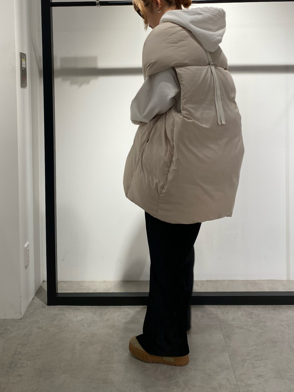 ホワイト系のダウンベスト、ブラック系のその他パンツを着用したレディースの冬コーディネートの3枚目の写真