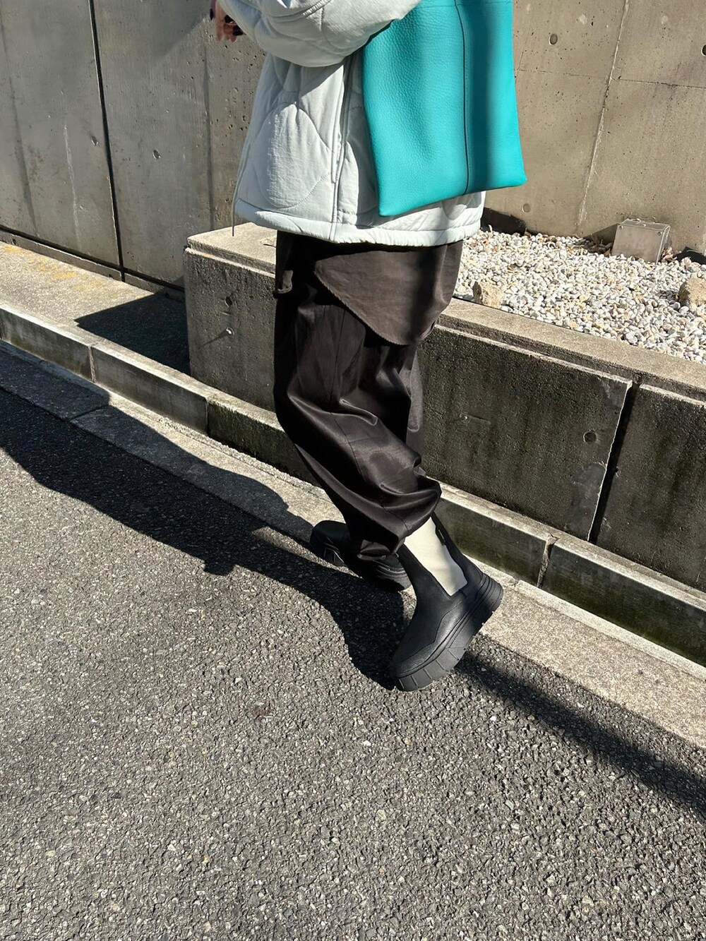 ブルー系のトートバッグ、ブラック系のブーツを着用したレディースの冬コーディネートの4枚目の写真