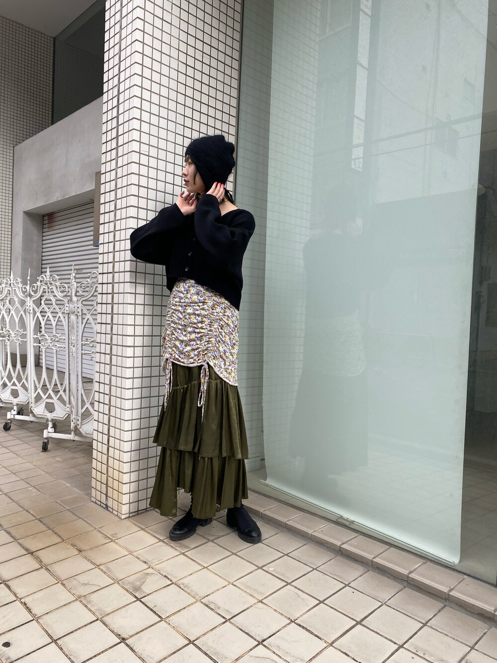 ブラック系のカーディガン/ボレロ、グリーン系のスカートを着用したレディースの冬コーディネートの3枚目の写真