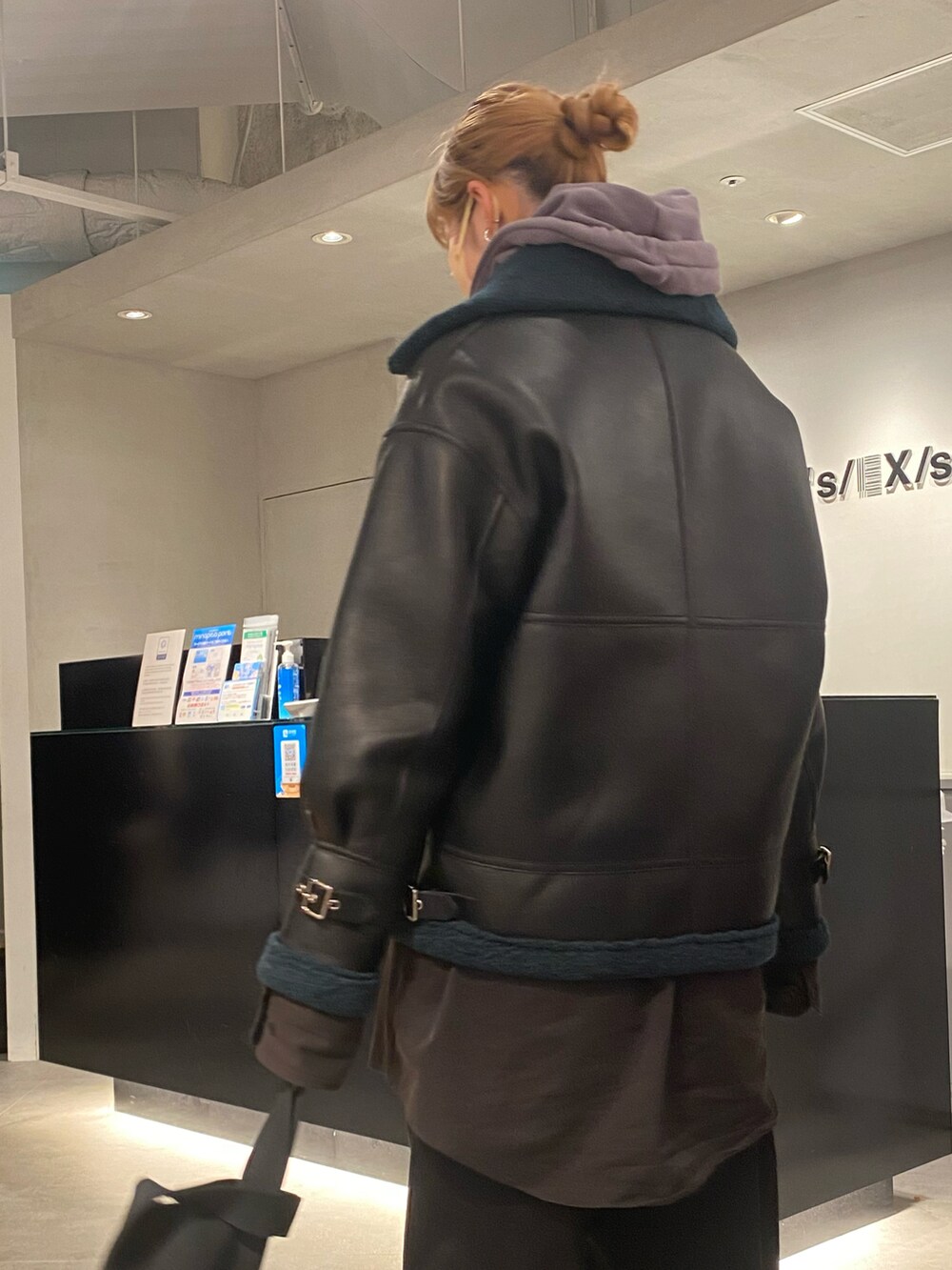 ブラック系のミリタリージャケットを着用したレディースの冬コーディネートの2枚目の写真