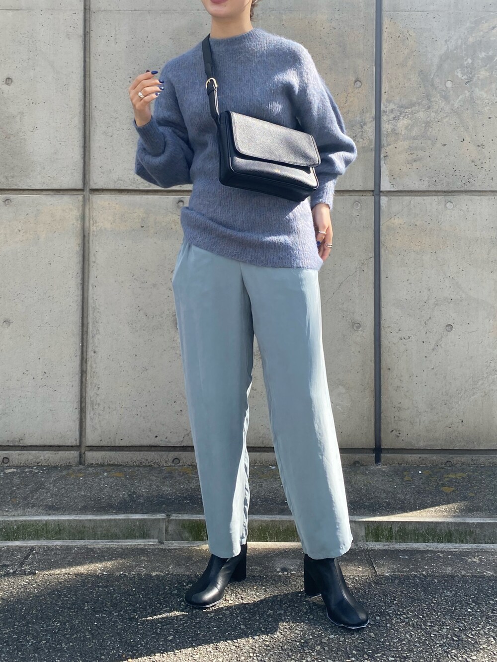 ブラック系のショルダーバッグ、ブラック系のブーツを着用したレディースの冬コーディネートの2枚目の写真