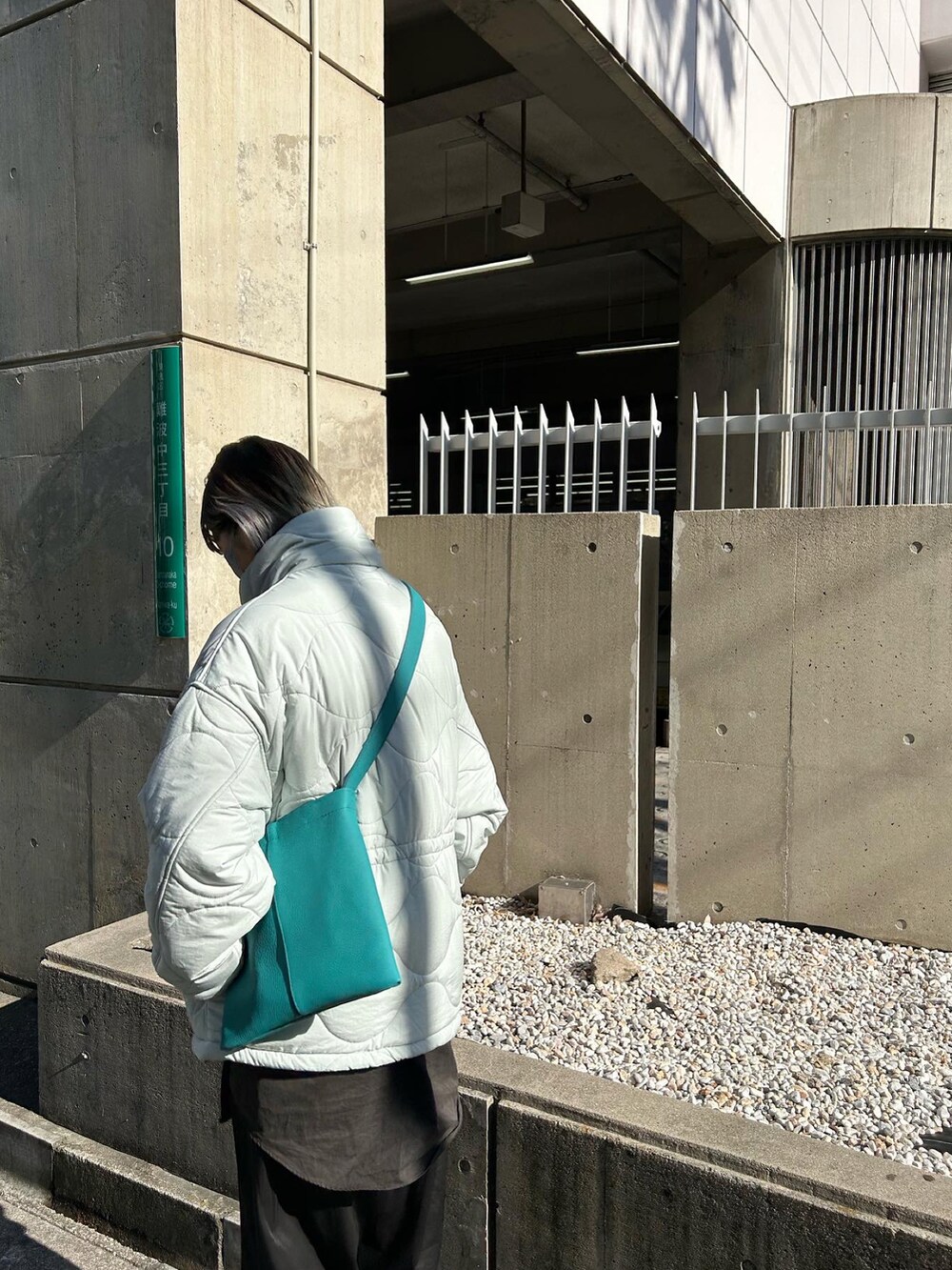 ブルー系のトートバッグ、ブラック系のブーツを着用したレディースの冬コーディネートの3枚目の写真