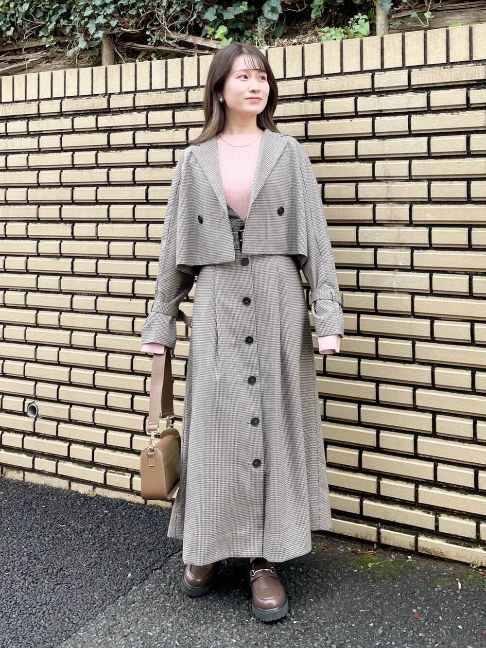 ブラウン系のテーラードジャケット、ピンク系のニット/セーター、ブラウン系のショルダーバッグを着用したレディースの冬コーディネートの2枚目の写真