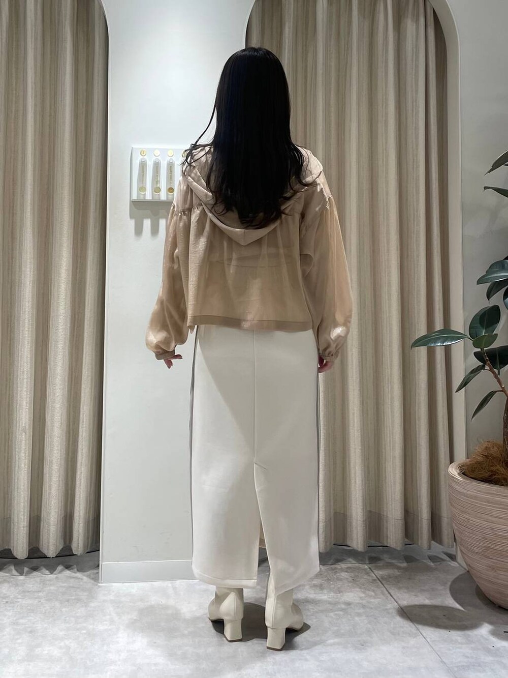 ホワイト系のスカート、ホワイト系のTシャツ/カットソー、ホワイト系のブーツを着用したレディースの冬コーディネートの2枚目の写真