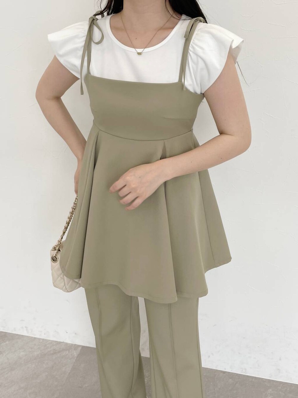 グリーン系のキャミソール、グリーン系のその他パンツ、ホワイト系のショルダーバッグを着用したレディースの春コーディネートの3枚目の写真