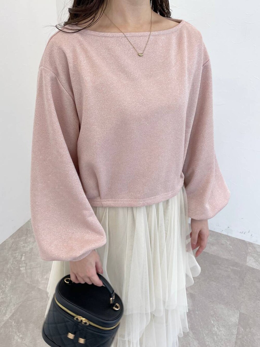 グレー系のブーツ、ブラック系のショルダーバッグ、ホワイト系のスカートを着用したレディースの冬コーディネートの3枚目の写真