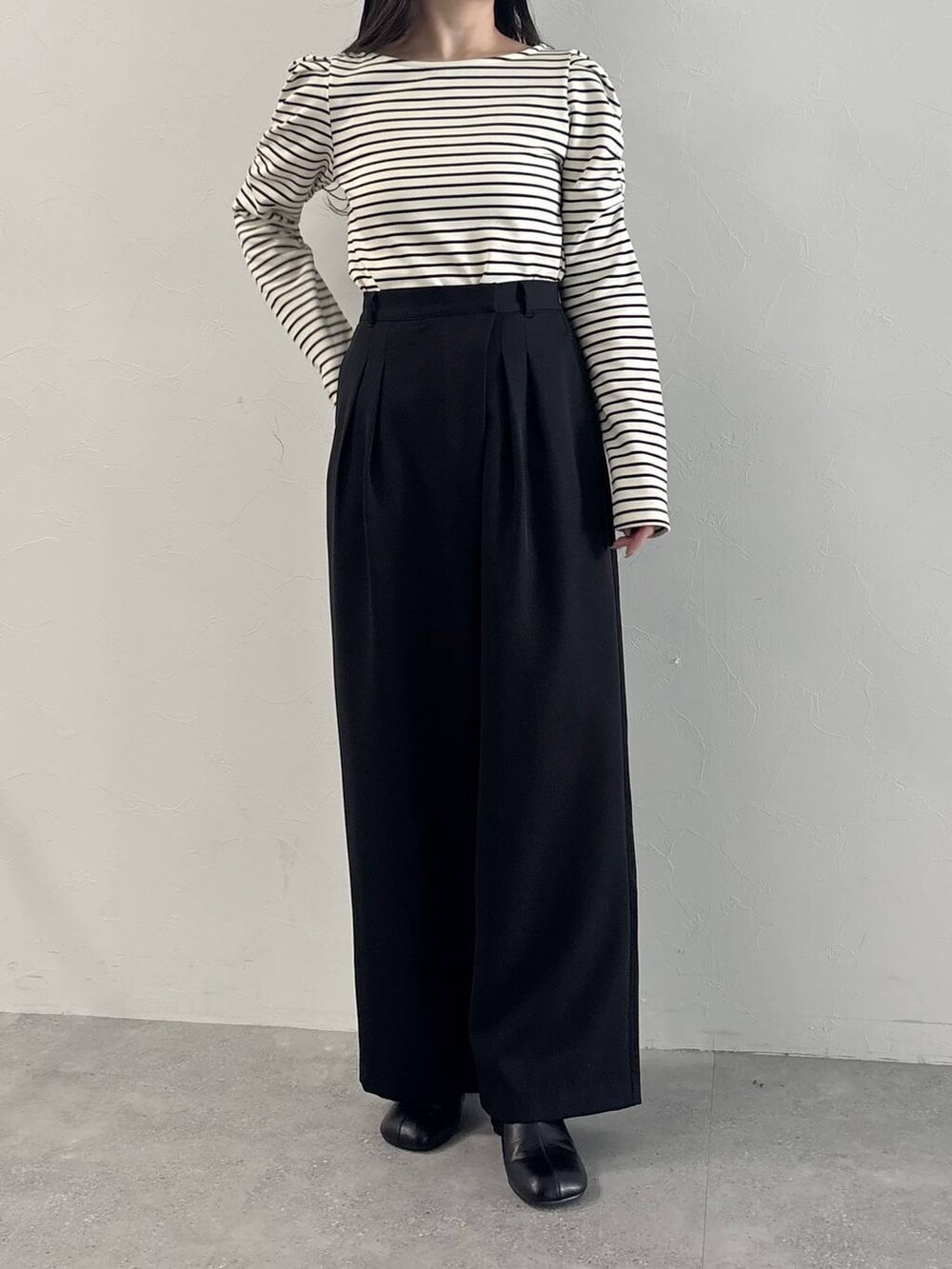 ホワイト系のショルダーバッグ、ブラック系のパンプス、ブラック系のスラックスを着用したレディースの春コーディネートの5枚目の写真