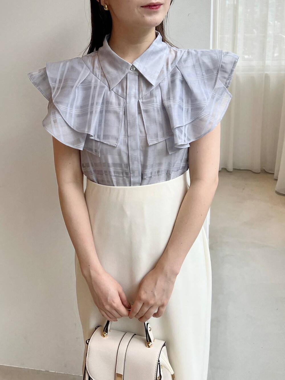 ゴールド系のパンプス、ホワイト系のショルダーバッグ、ブルー系のシャツ/ブラウスを着用したレディースの夏コーディネートの4枚目の写真