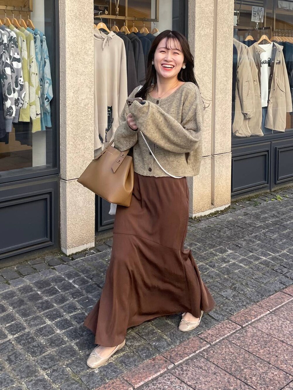 ブラウン系のスカート、グリーン系のカーディガン/ボレロ、ゴールド系のネックレスを着用したレディースの秋コーディネートの2枚目の写真