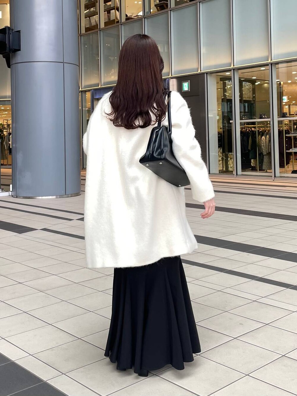 ホワイト系のニット/セーター、ホワイト系のチェスターコート、ブラック系のブーツを着用したレディースの秋コーディネートの3枚目の写真