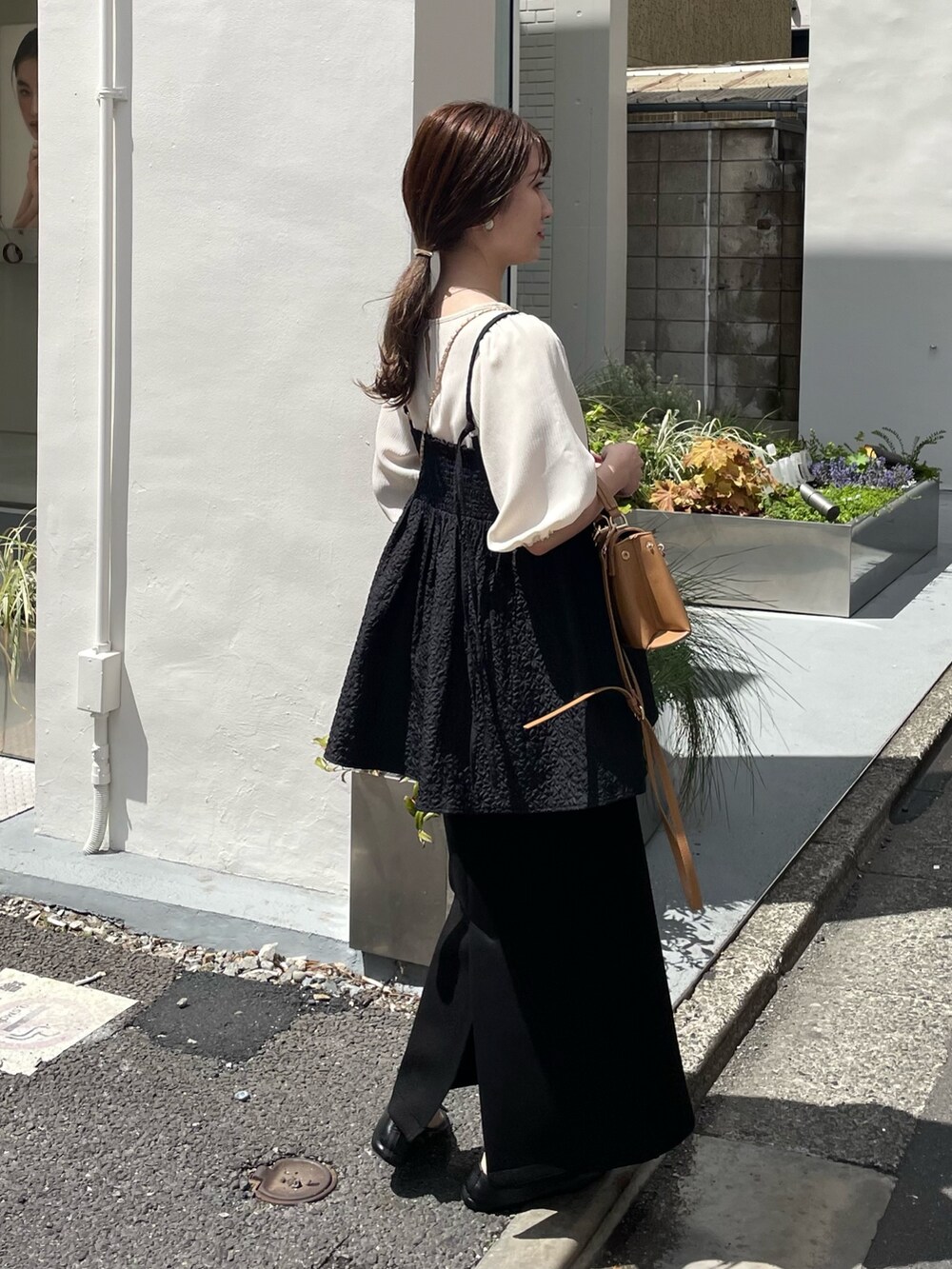 ブラウン系のショルダーバッグ、ホワイト系のシャツ/ブラウス、ブラック系のキャミソールを着用したレディースの春コーディネートの3枚目の写真