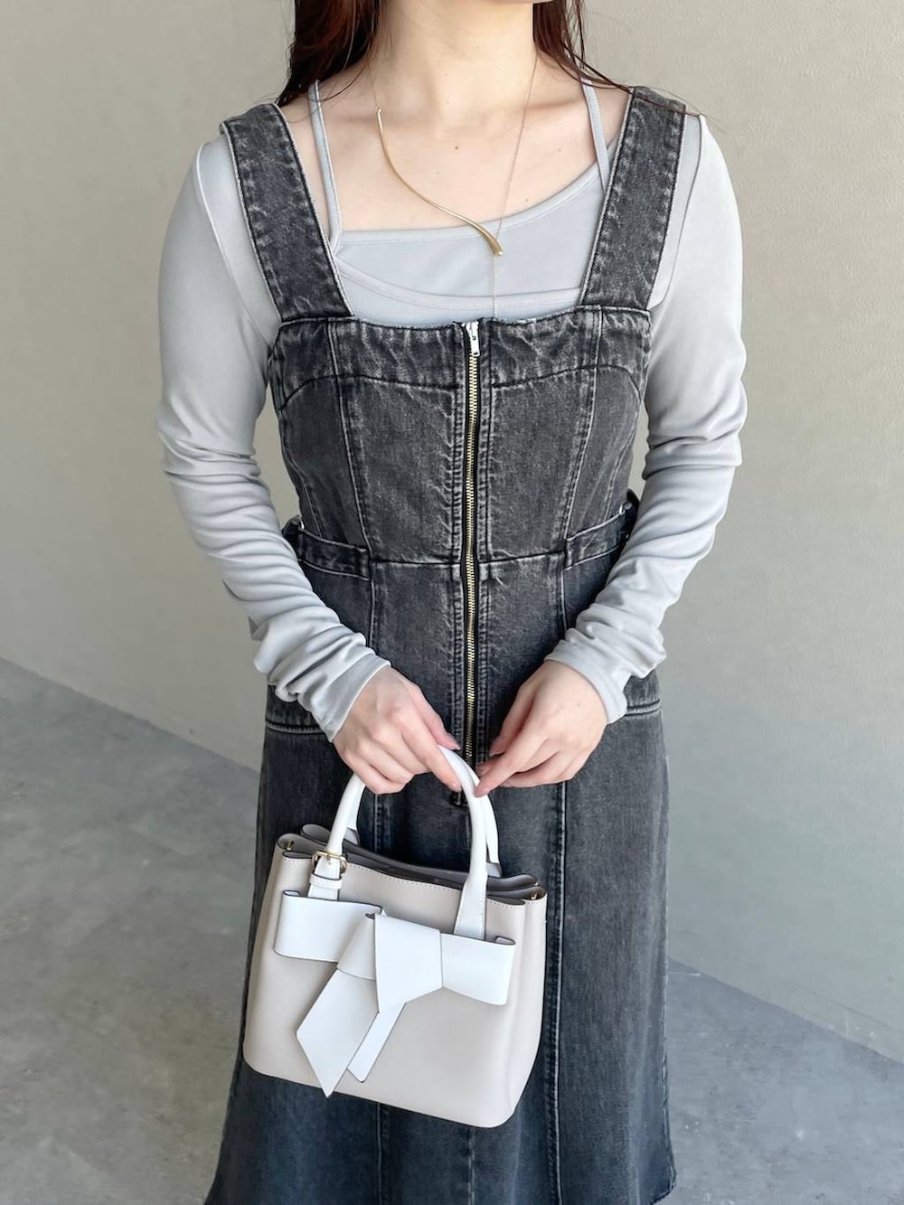 ブラック系のジャンパースカート、ベージュ系のショルダーバッグ、シルバー系のバレエシューズを着用したレディースの冬コーディネートの3枚目の写真