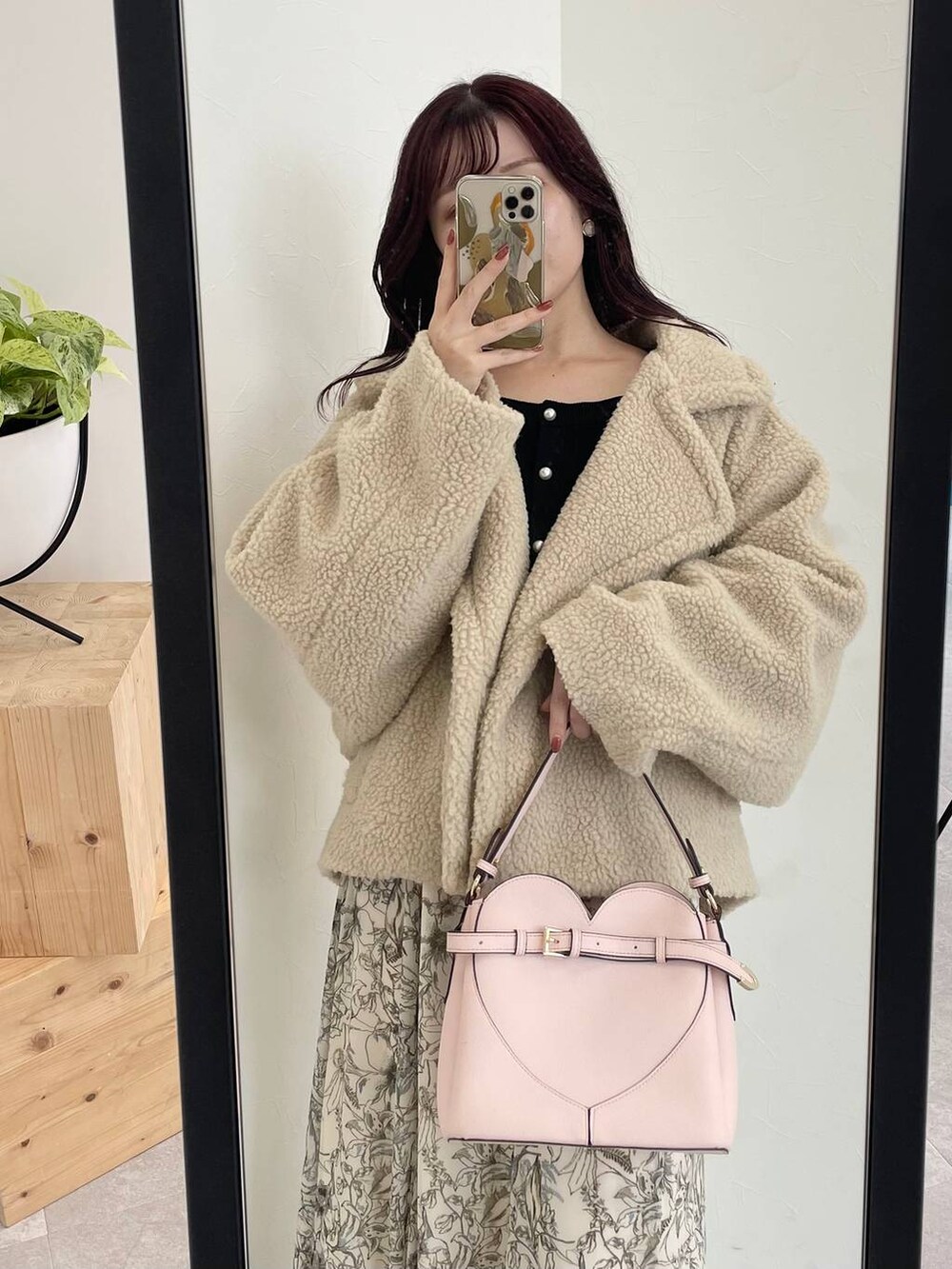 ベージュ系のピーコート、ピンク系のショルダーバッグ、ホワイト系のスカートを着用したレディースの秋コーディネートの3枚目の写真