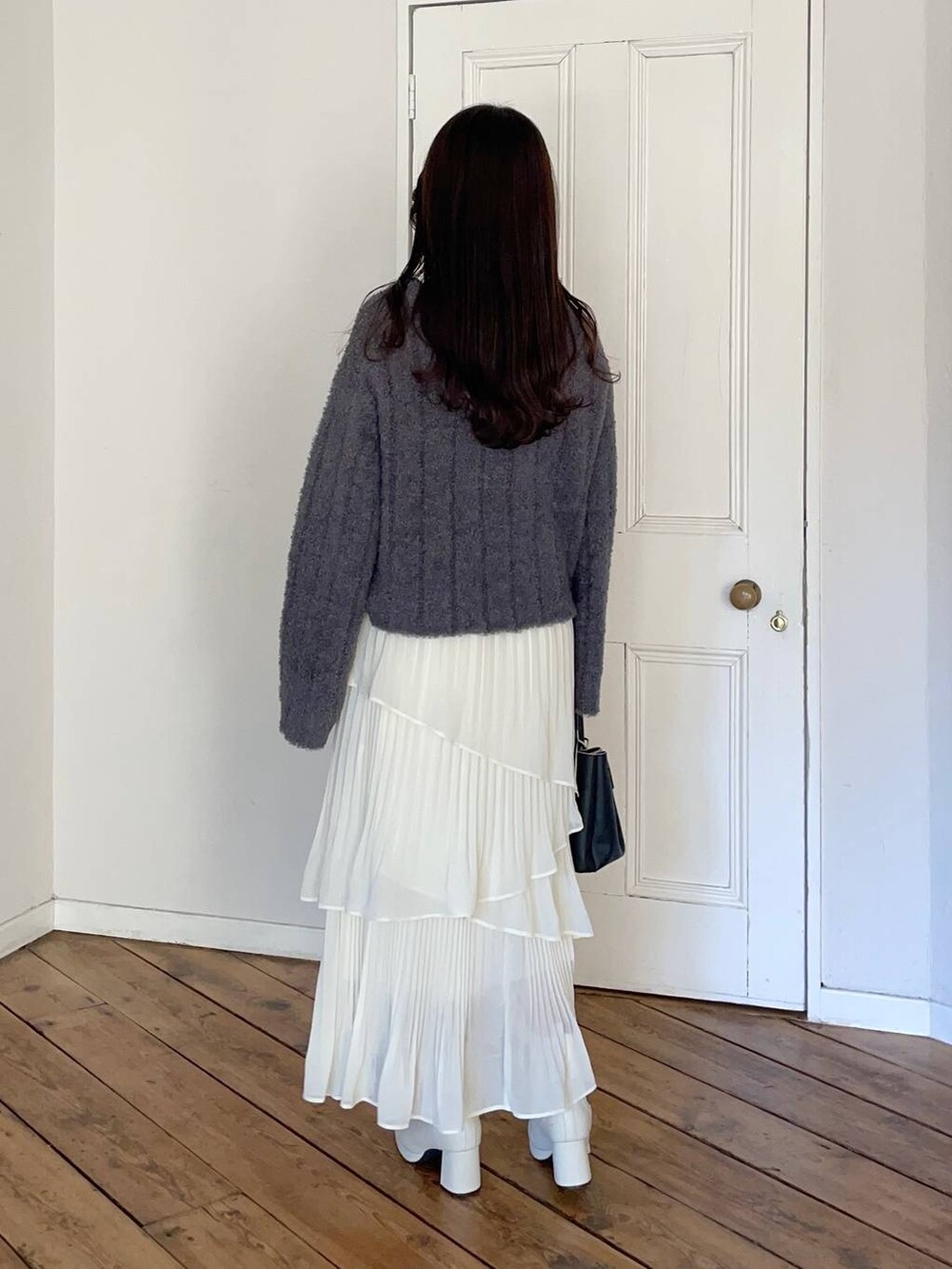 ホワイト系のブーツ、ベージュ系のブルゾン、ブラック系のショルダーバッグを着用したレディースの冬コーディネートの4枚目の写真