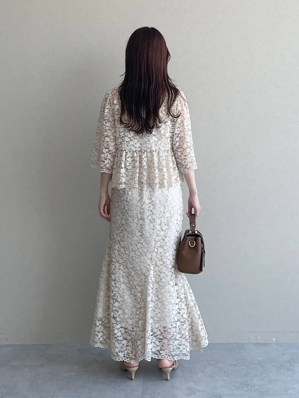 ゴールド系のパンプス、ブラウン系のショルダーバッグ、ベージュ系のシャツ/ブラウスを着用したレディースの夏コーディネートの2枚目の写真